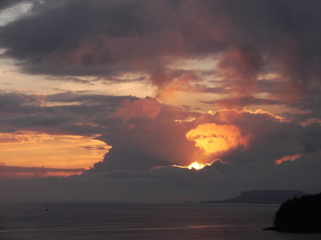 Sun breaking through clouds over the sea